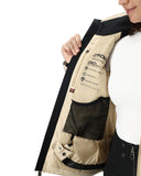 Close-up of a person wearing a beige and black jacket with visible branding on a white background