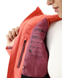 Close-up of a person wearing an orange jacket with Spyder branding and EXO Shield feature details.