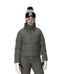 Person wearing a gray winter jacket, pants, gloves, and a beanie with goggles on a white background