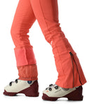 Close-up of coral ski pants and white ski boots on a white background