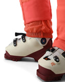 Close-up of ski boots with orange pants on a white background