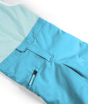 Close-up of blue pants with a white shirt underneath on a light background