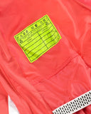 Close-up of a red jacket with a green label on the chest.
