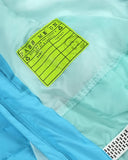 Close-up of a green label on a light blue garment with visible stitching details.