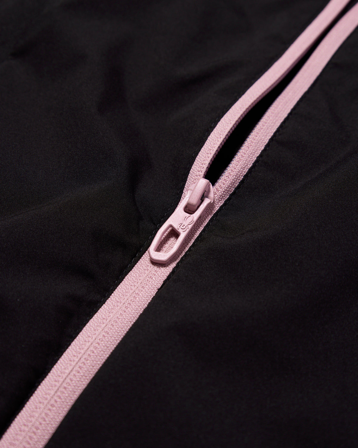 Close-up of a pink zipper on a black background