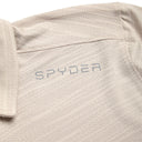 Close-up of a beige polo shirt with 'Spyder' branding on the chest.