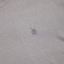 Close-up of a textured gray fabric with a small logo.