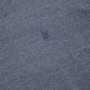Close-up of a textured gray fabric with a small logo.