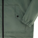 Close-up of a green jacket with a pocket and zipper detail.