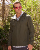 Man wearing a green jacket with a brand logo outdoors